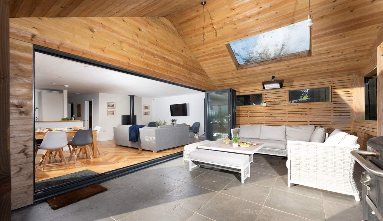 The large bi-fold doors connect the open plan living-room with the covered patio.