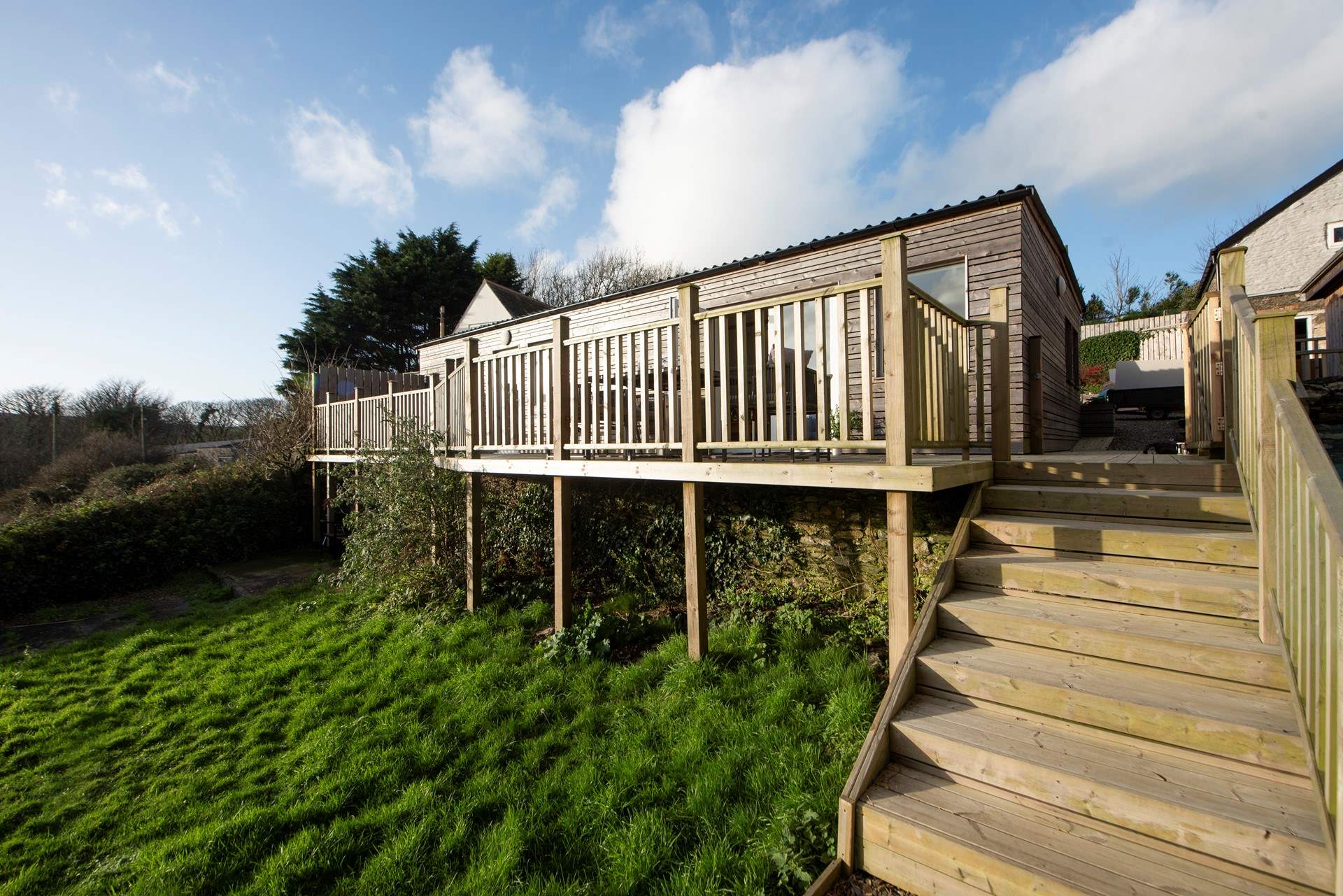 Steps lead down to a little private lawned area, there's also plenty of green open space around the pool and tennis court.