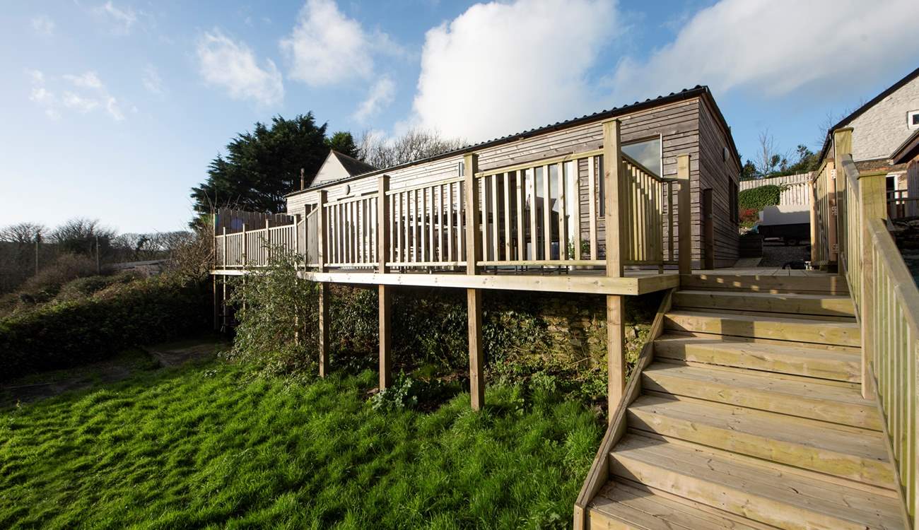 Steps lead down to a little private lawned area, there's also plenty of green open space around the pool and tennis court.