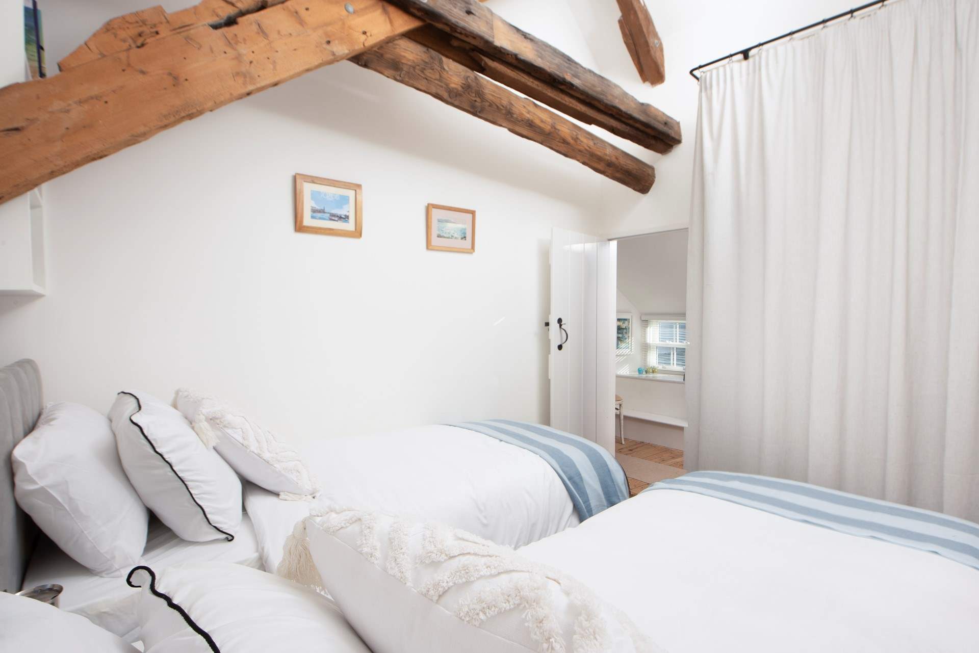 Appreciate the ancient structure of this historic house, the beams run through the entire property. Plenty of hanging space behind the curtain.