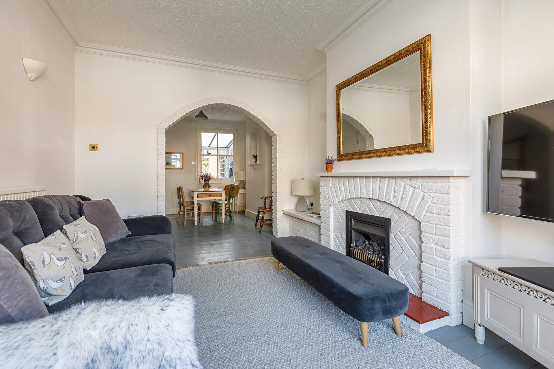 The sitting/dining-room with an ornamental fireplace in the sitting-area.