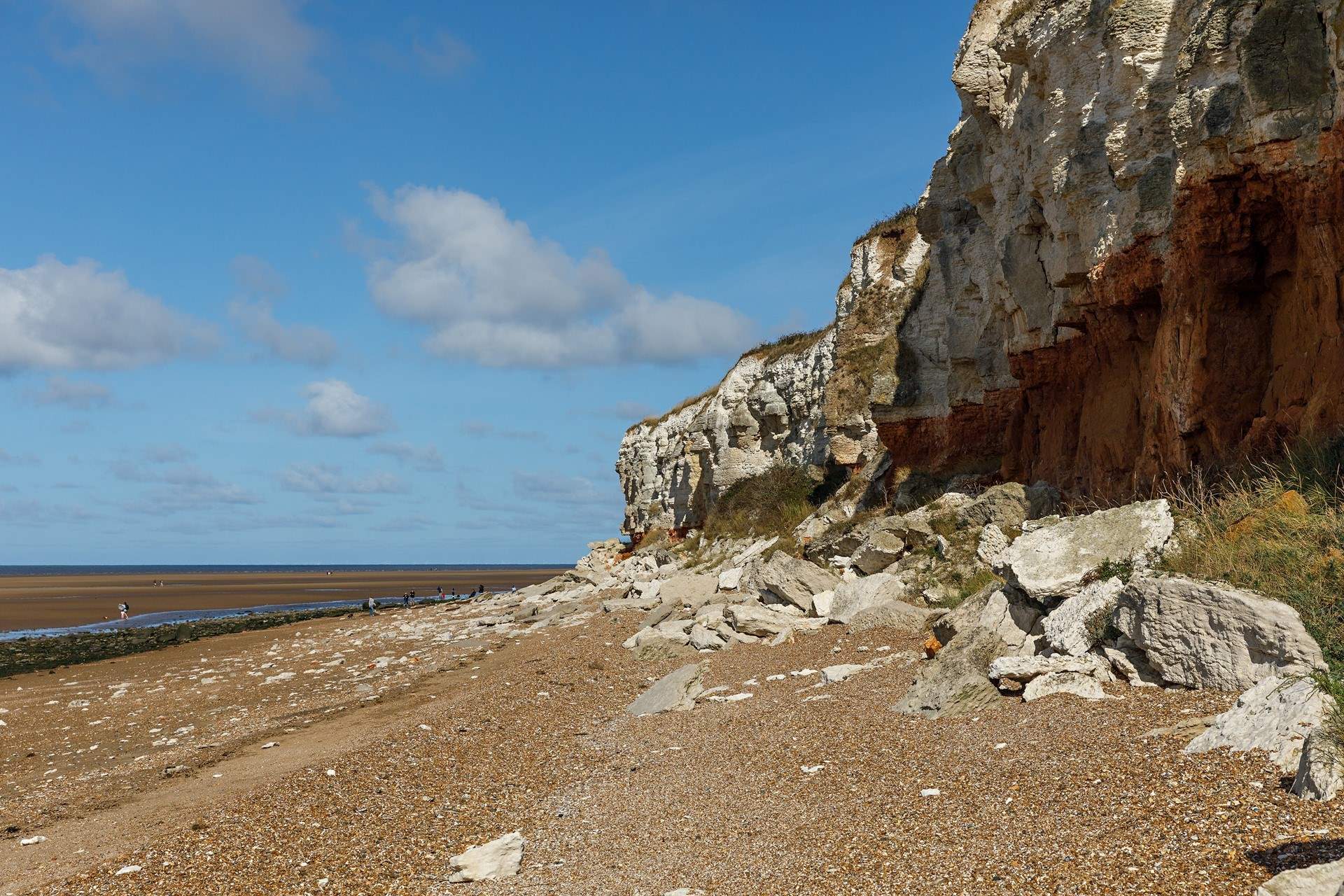 Explore the rockpools at low tide from 'Sunny Hunny' against the iconic striped cliffs.