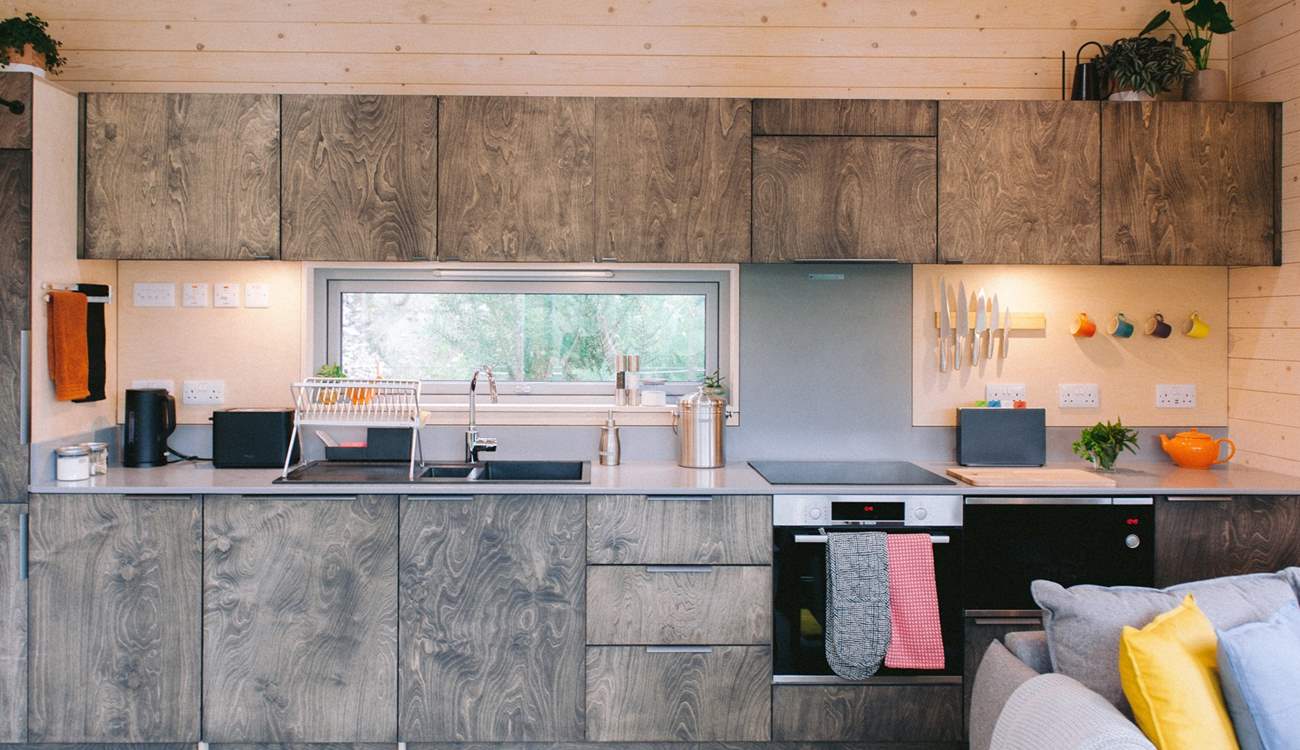 The open-plan living space unfolds effortlessly, where the beautifully sleek kitchen sits at its heart.