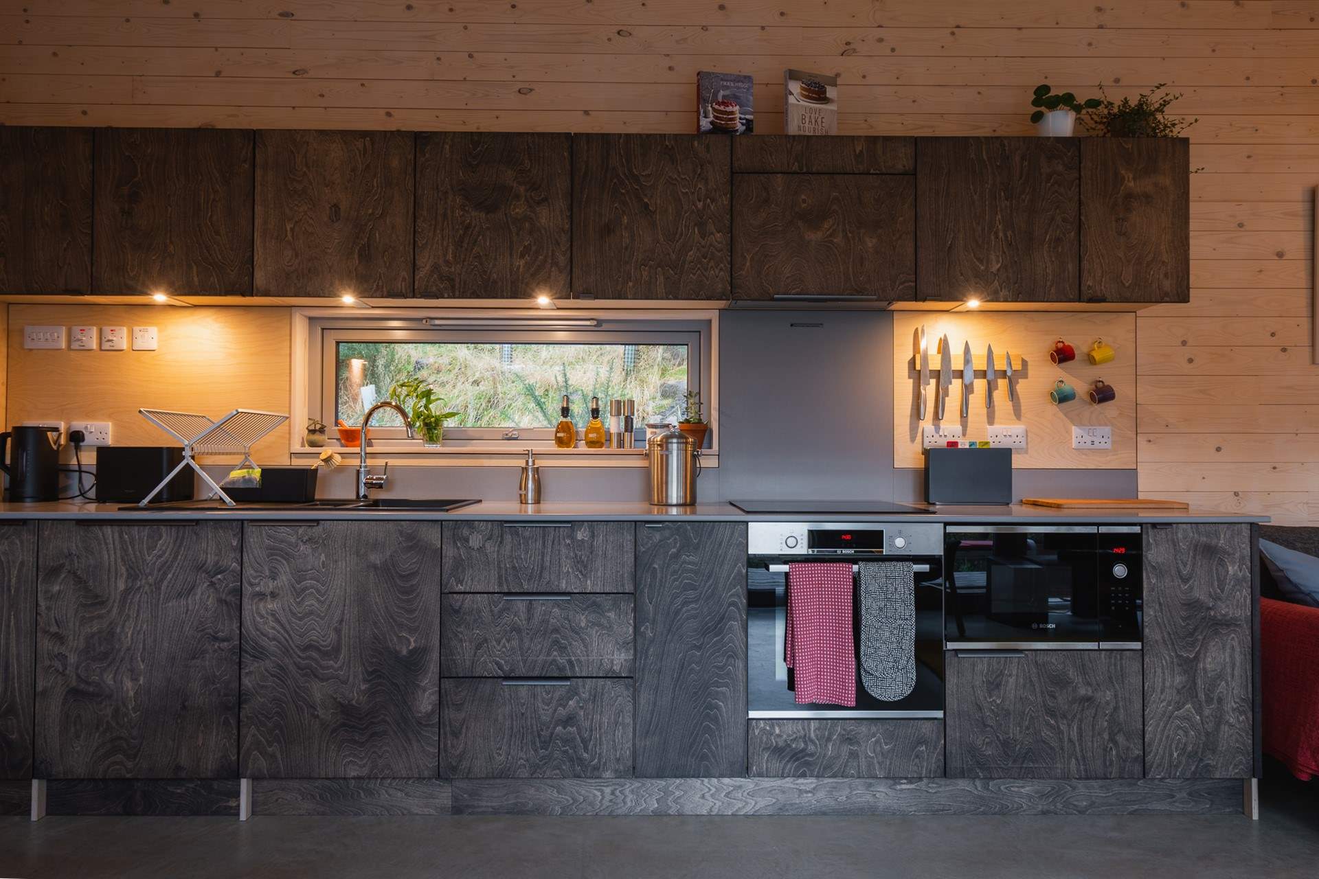 The sleek kitchen is thoughtfully equipped with everything you could need. 