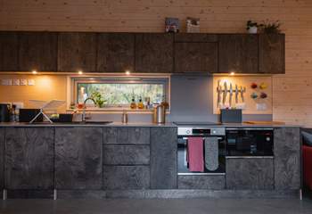 The sleek kitchen is thoughtfully equipped with everything you could need. 