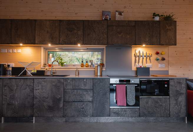 The sleek kitchen is thoughtfully equipped with everything you could need. 