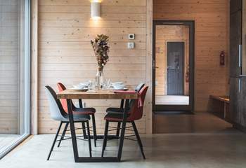 Inside, soft, neutral tones echo the woodland just beyond the glass.