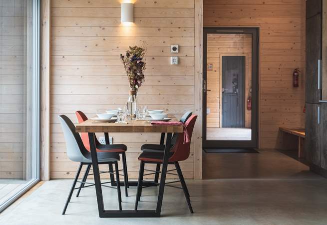 Inside, soft, neutral tones echo the woodland just beyond the glass.