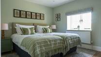 Bedroom 3 is serene and wonderfully spacious. It features large luxury single beds and lovely views out.