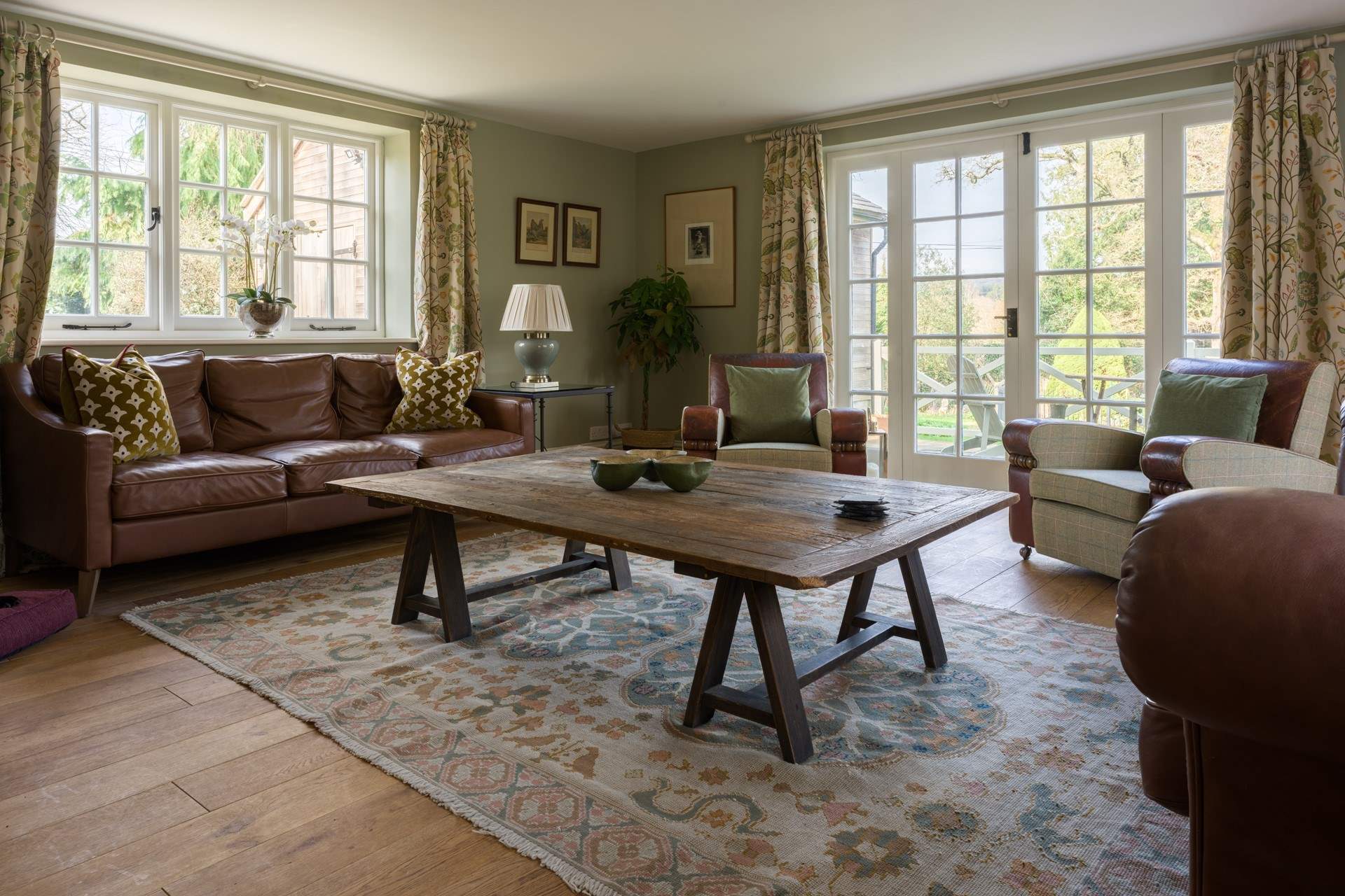 The grand sitting-room is triple-aspect with two sets of doors onto the terraces and lots of comfy seating - it's the ideal space to gather everyone together and enjoy indoor/outdoor living.