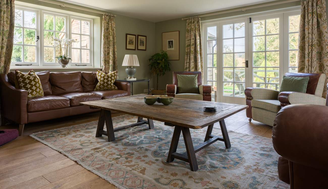 The grand sitting-room is triple-aspect with two sets of doors onto the terraces and lots of comfy seating - it's the ideal space to gather everyone together and enjoy indoor/outdoor living.