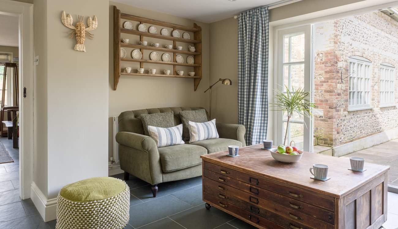 This lovely little nook at the end of the kitchen has comfy seating and is the perfect spot for a morning coffee with the doors open to the garden.