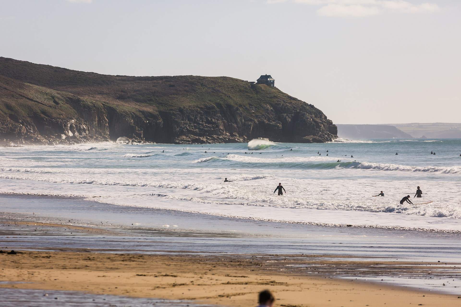 The surfers catching the waves at Praa Sands. 