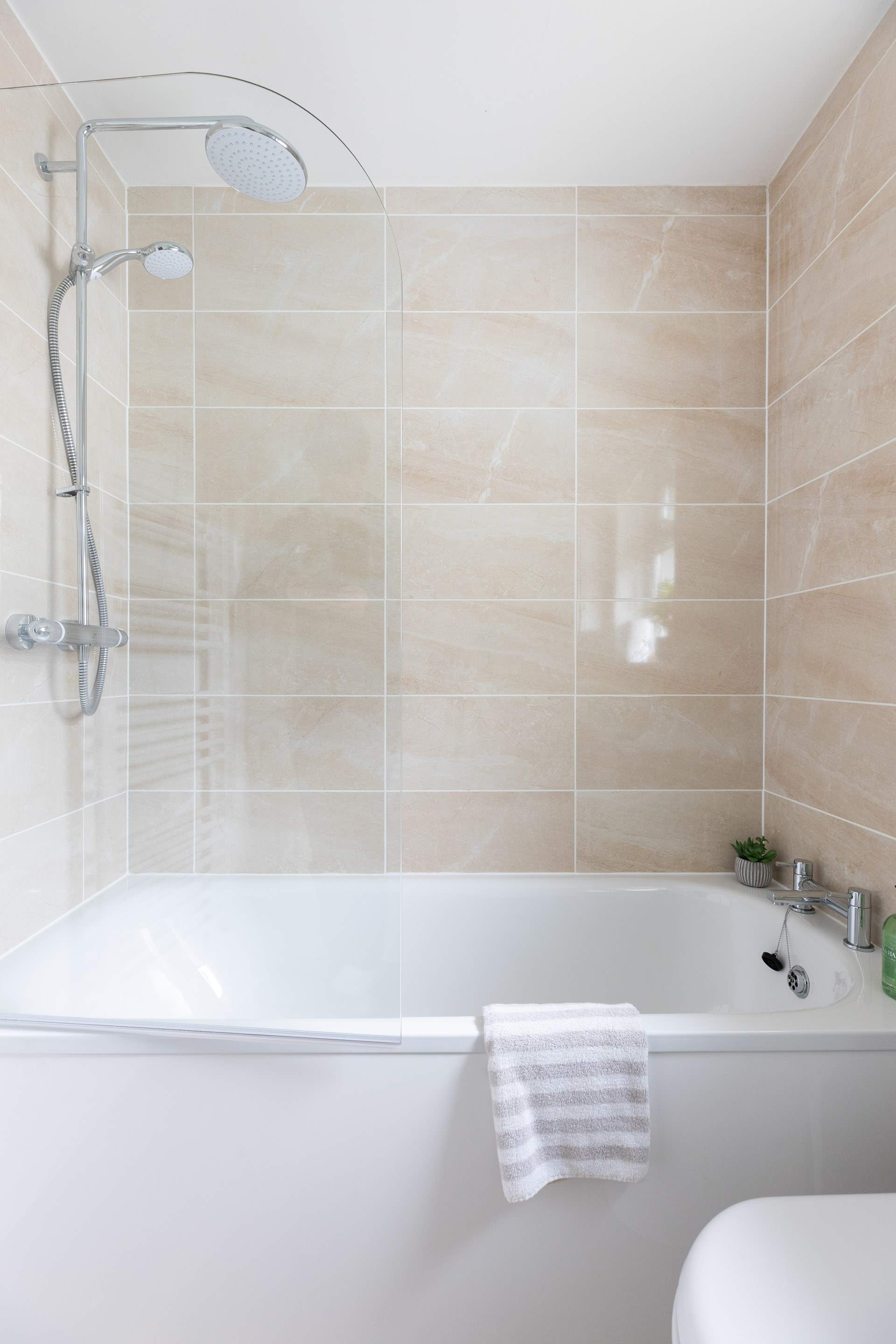 The bath has a shower over. 