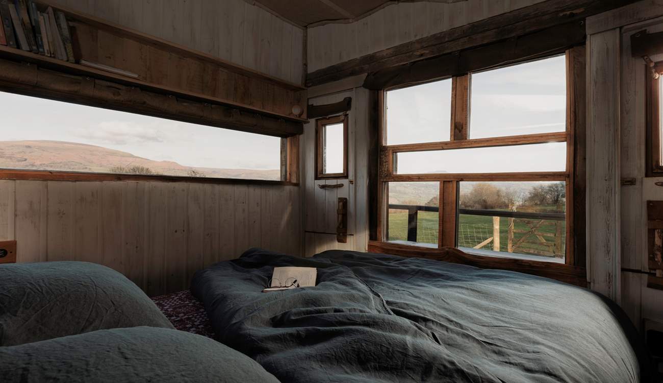 Wake slowly as the first light spills across the hills, enjoying the sunrise from the comfort of your bed.