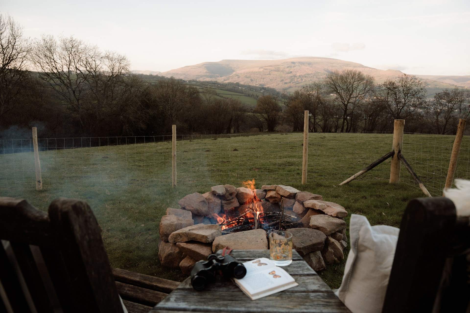 As evening settles, gather around the fire pit, watching the sun melt gently behind the hills.