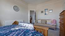 The spacious principal bedroom with king-size bed and a comfy sofa too!