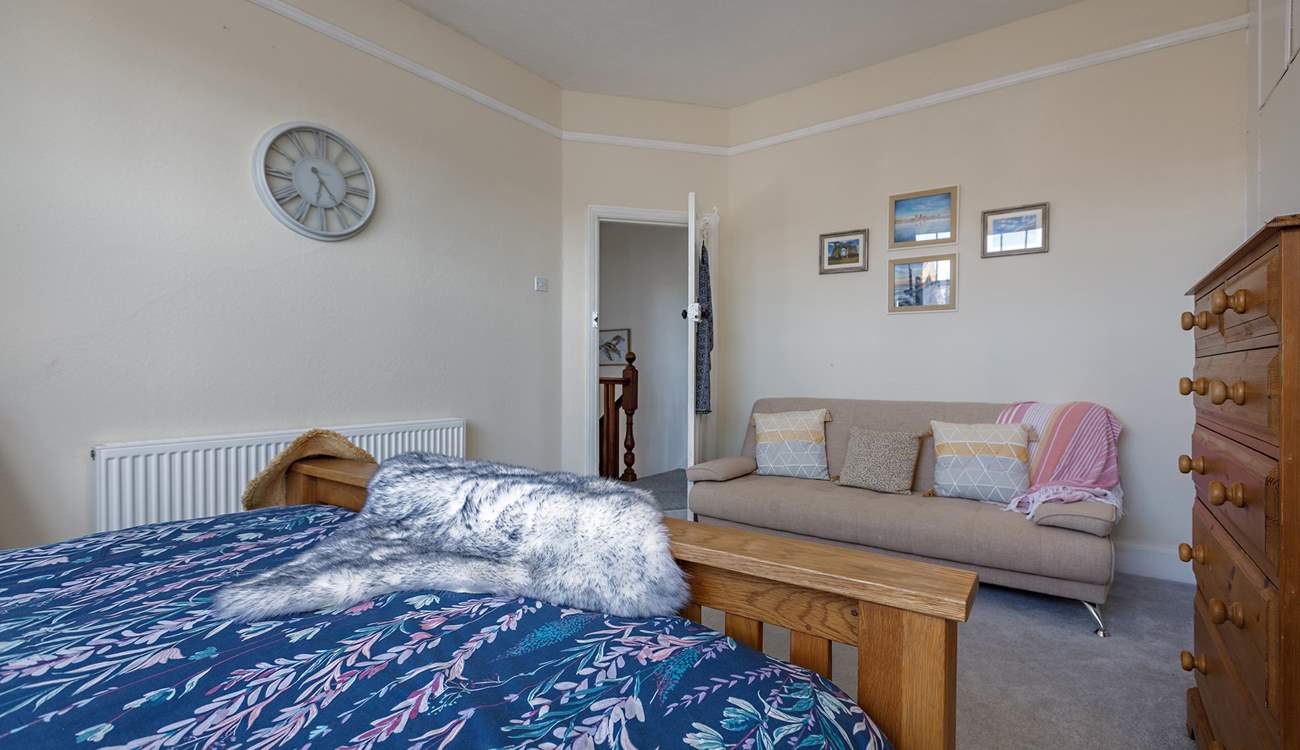 The spacious principal bedroom with king-size bed and a comfy sofa too!