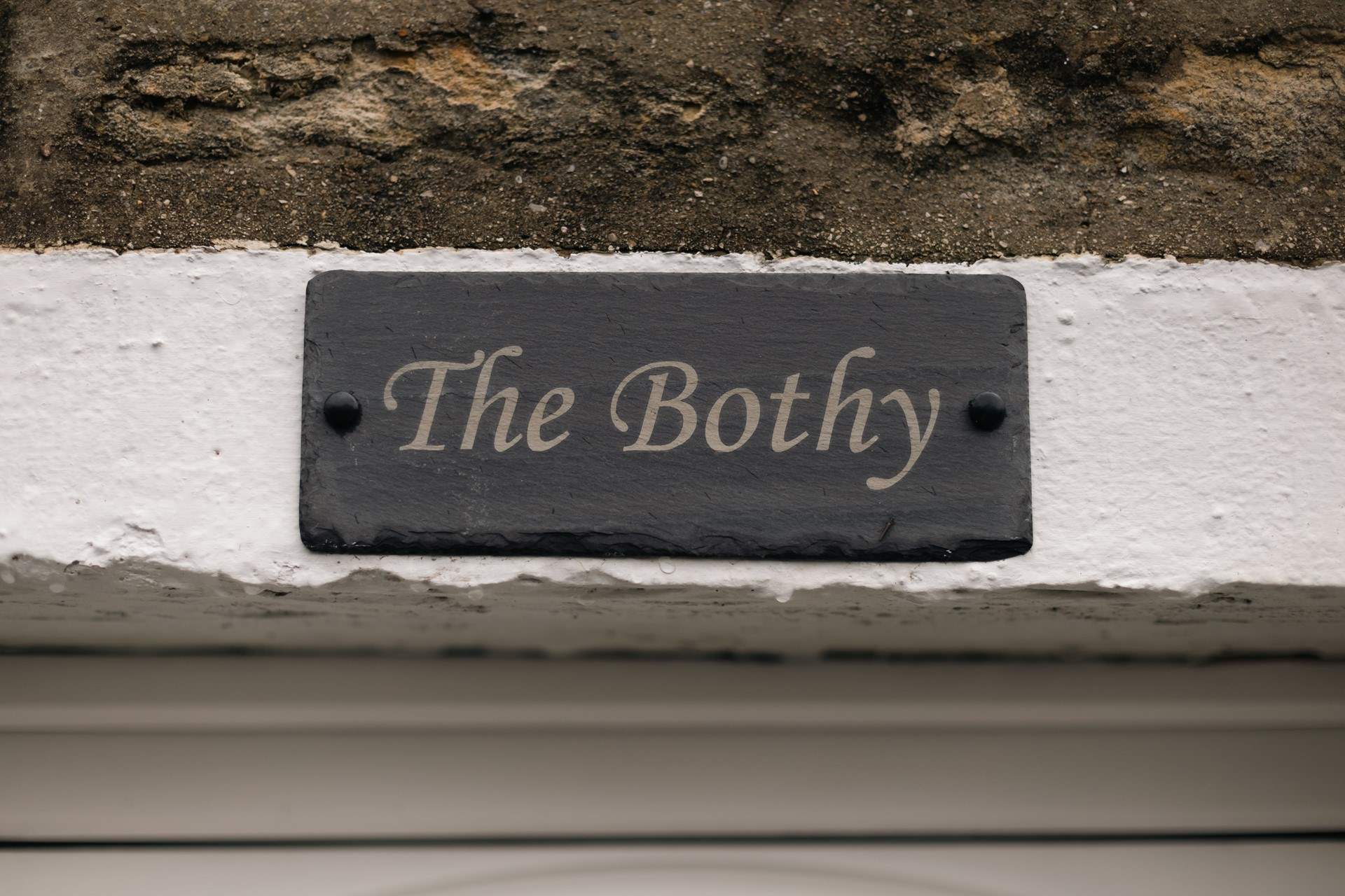 The Bothy sign on the stone façade of this pretty cottage.