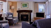 The lovely living-room is a cosy home-from-home space with lots of natural light and original features.