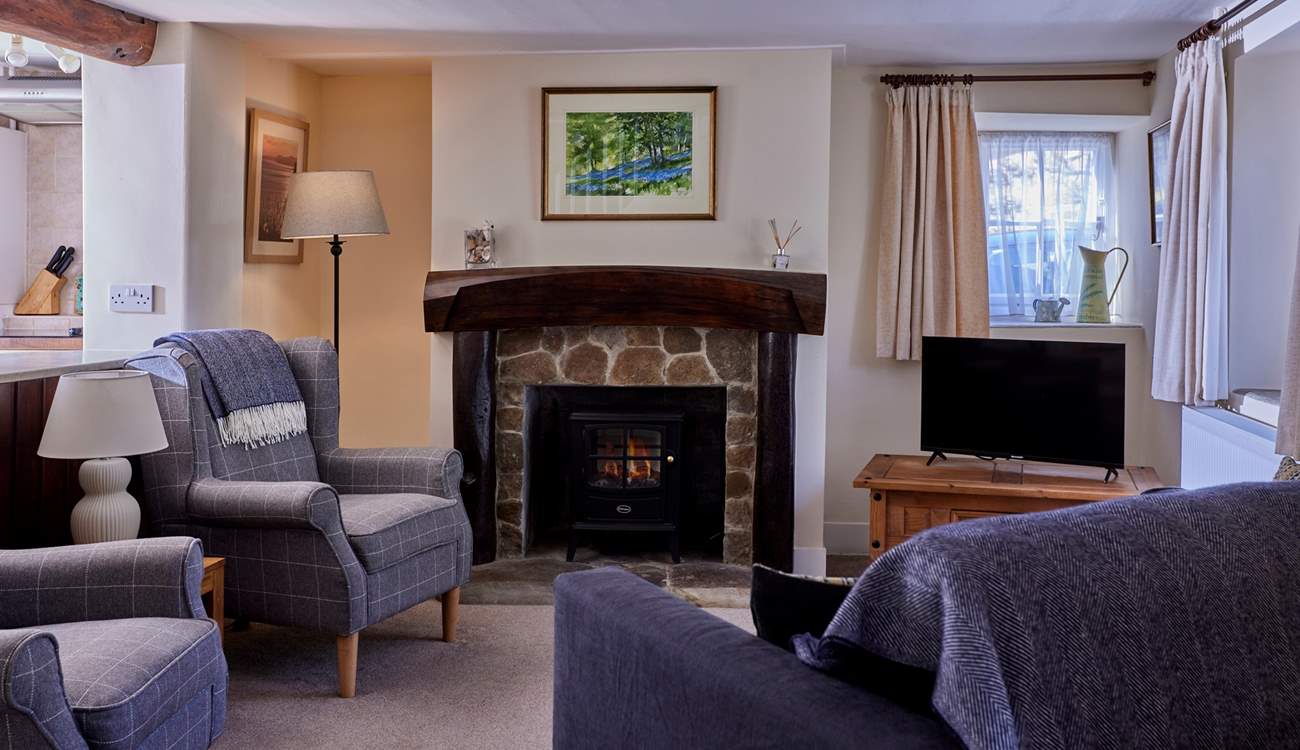 The lovely living-room is a cosy home-from-home space with lots of natural light and original features.