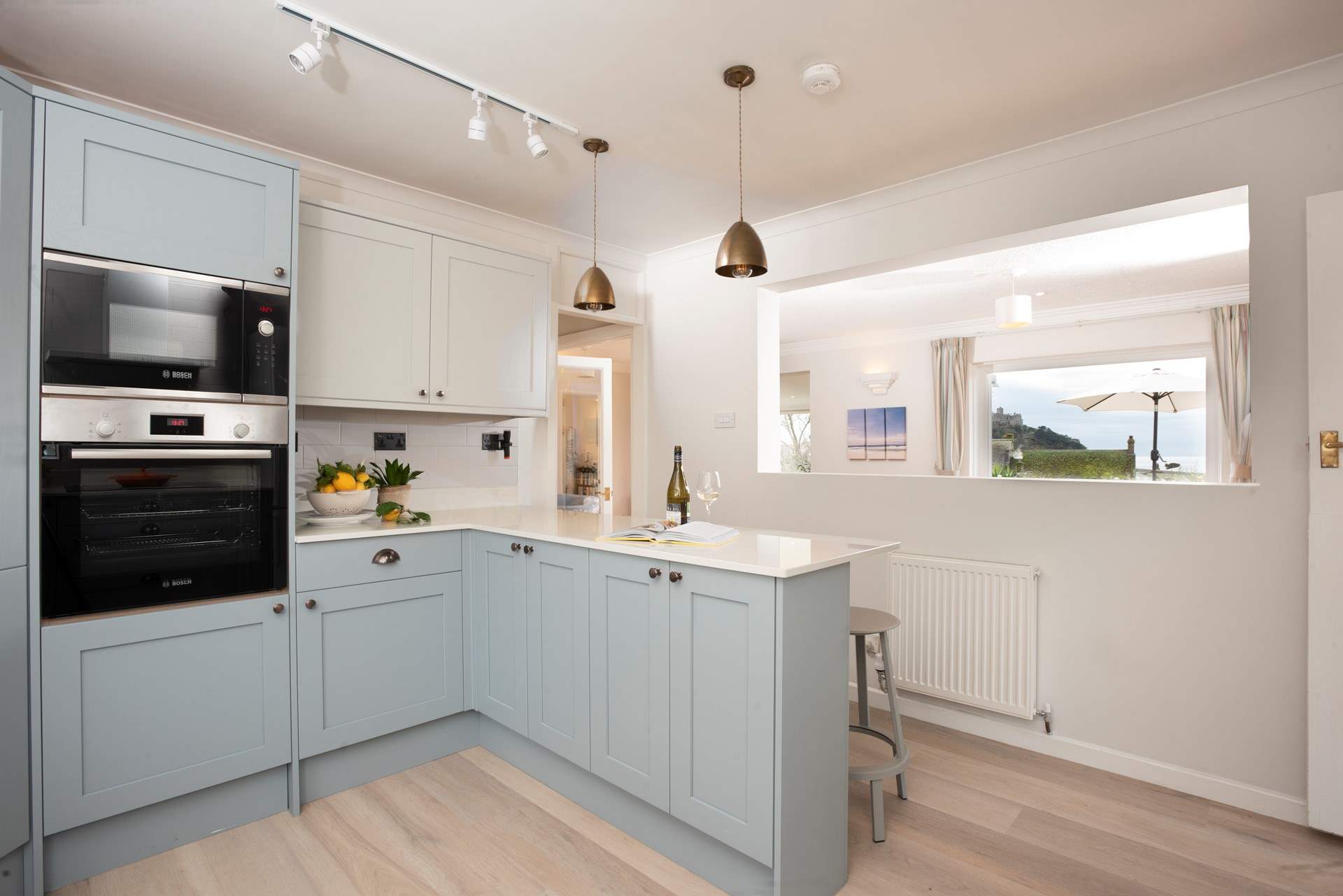 The kitchen looks through into the sitting area and onto the terrace outside.