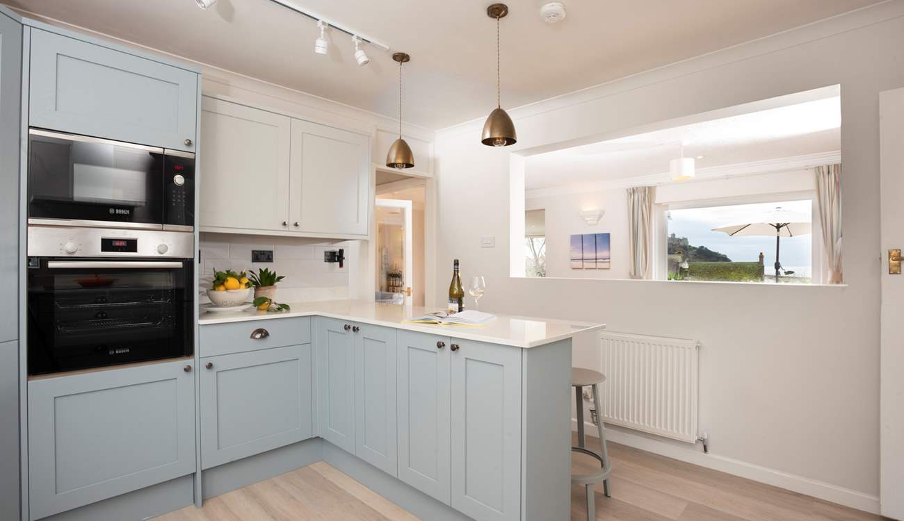 The kitchen looks through into the sitting-area and onto the terrace outside.