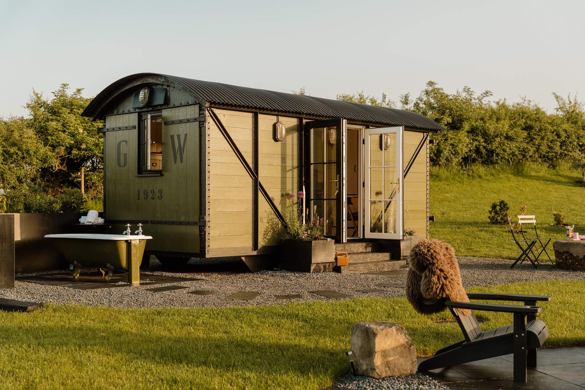 Juniper - A railway wagon in Wales with an outdoor bath: With wildflower meadows on your doorstep and beautiful views in every direction, Juniper is a restorative hideaway made for switching off and embracing a gentler pace of life.