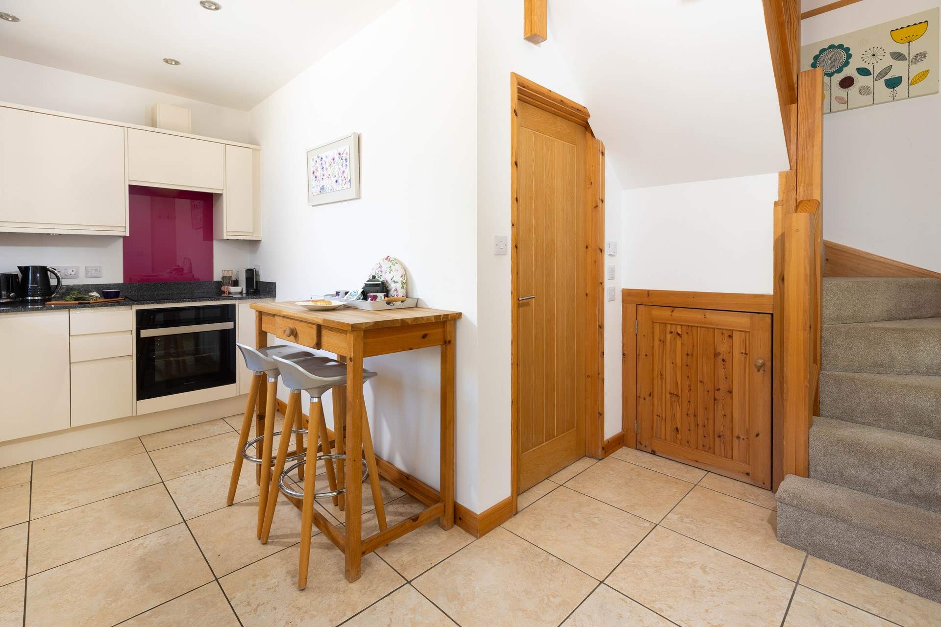 The kitchen has a handy breakfast-bar, with the bathroom through the door and stairs leading to the living space and bedroom. 
