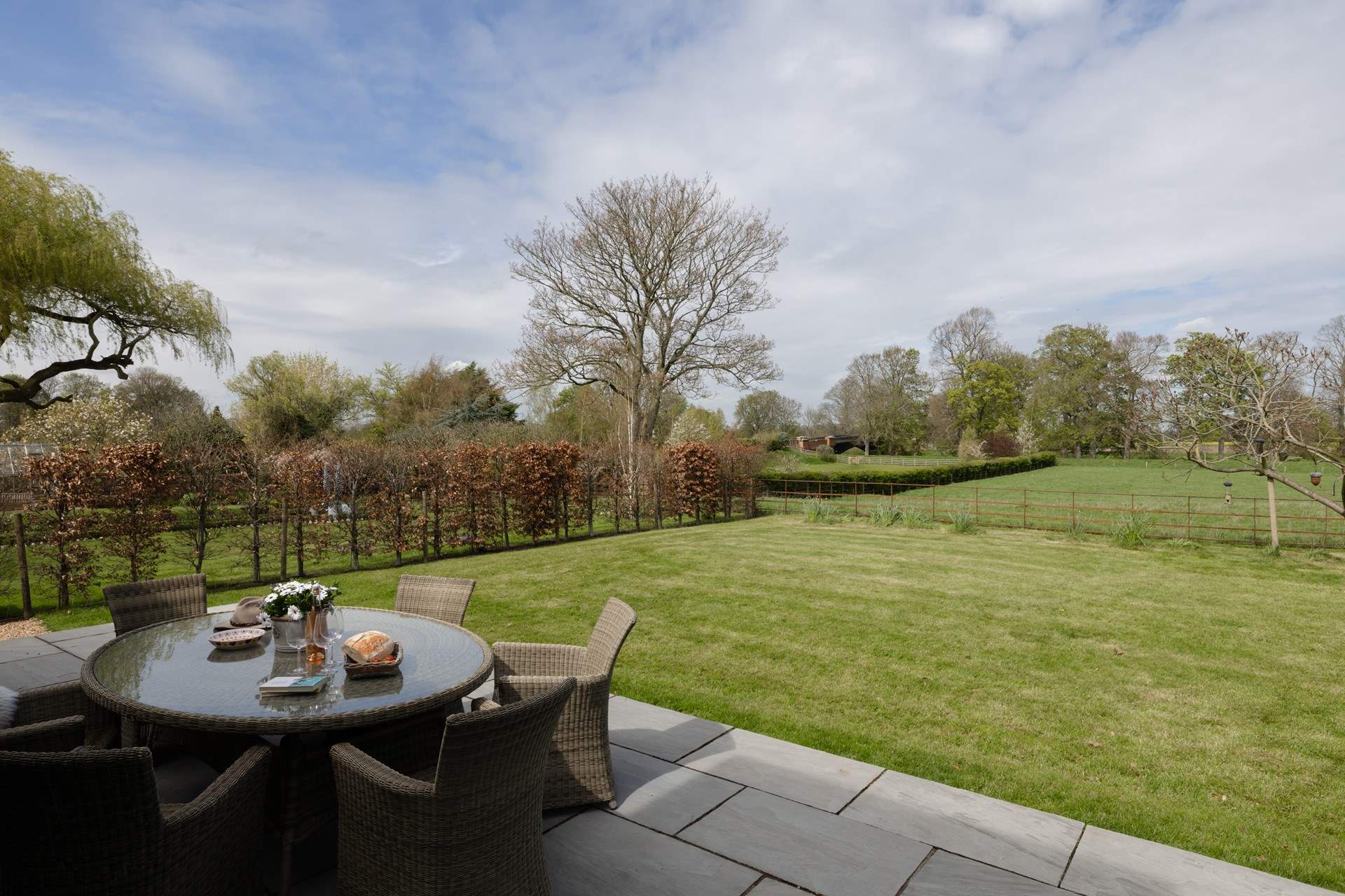 The large garden looks over the fields beyond.