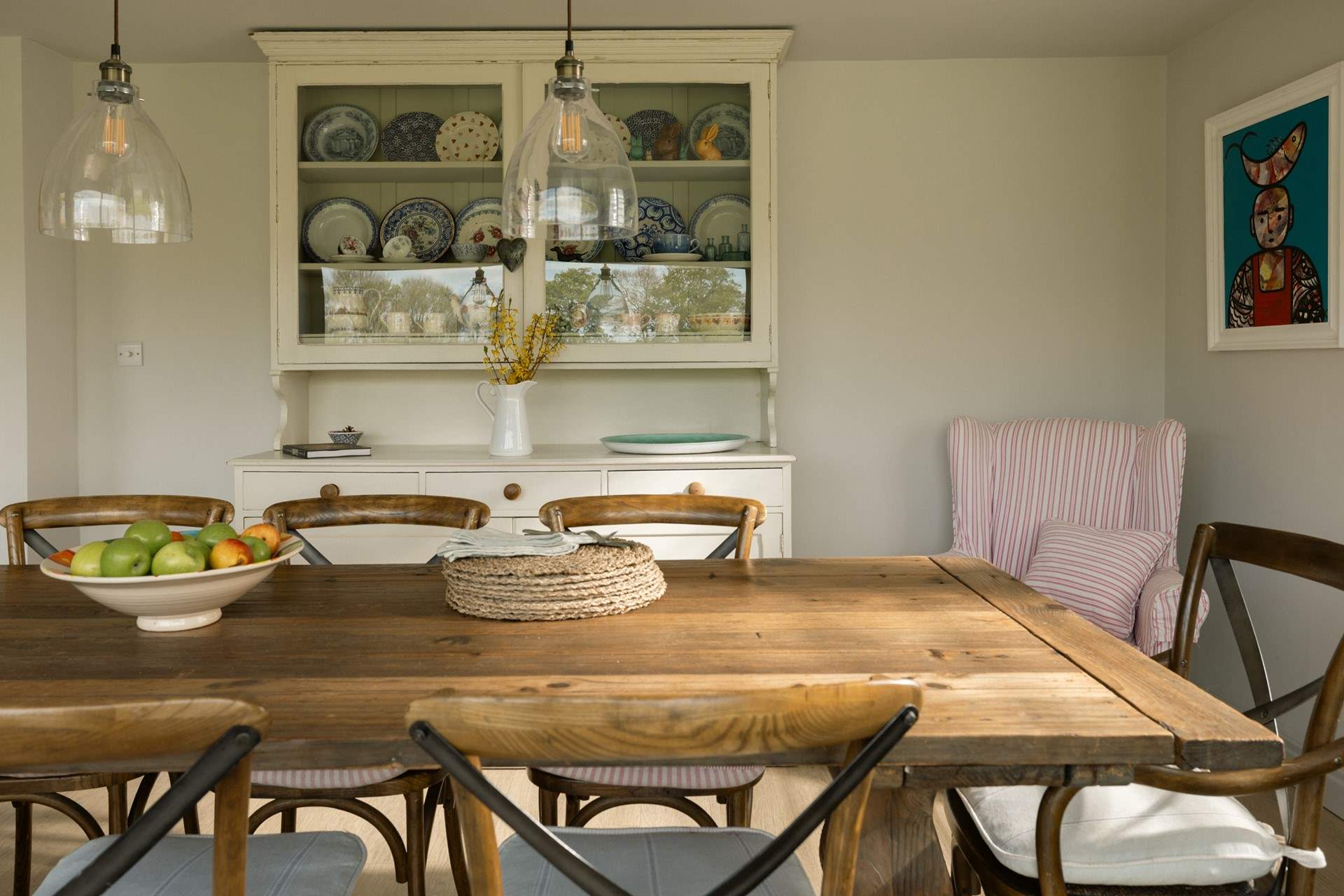 The owner has a very pretty collection of crockery displayed in the vintage dresser. 