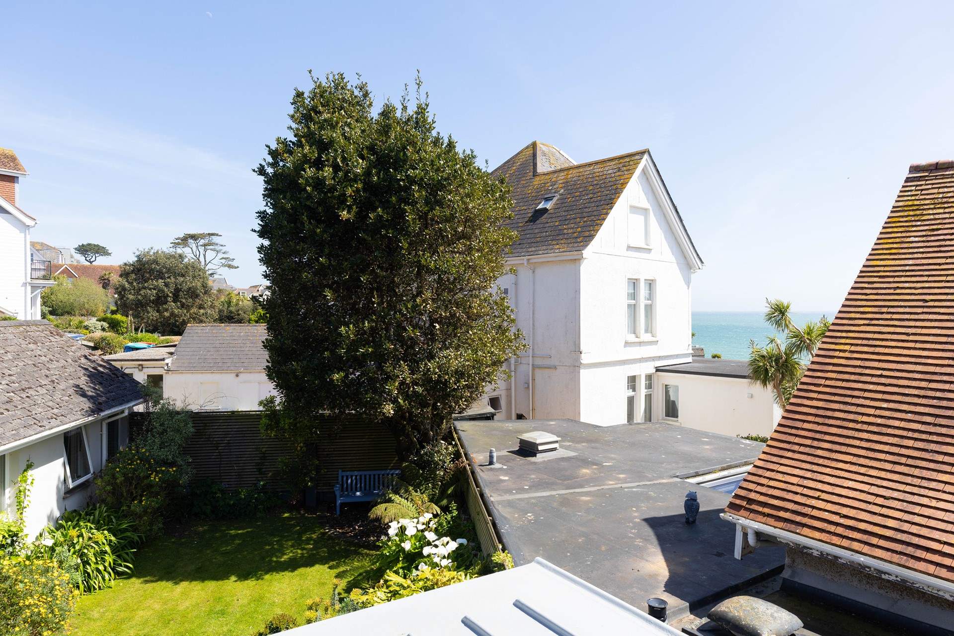 This bedroom's balcony overlooks the back garden and is bathed in the morning sun glimmering on the sea. 