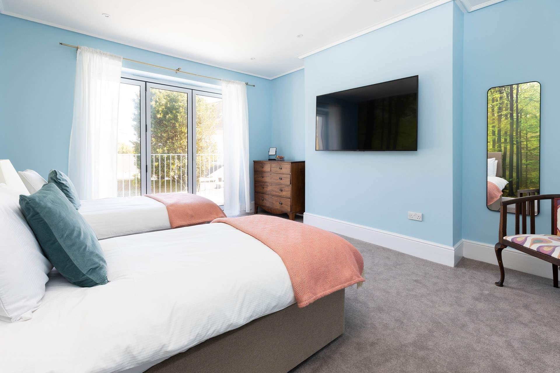 This bedroom has a huge TV and bi-fold doors opening to a small balcony. 