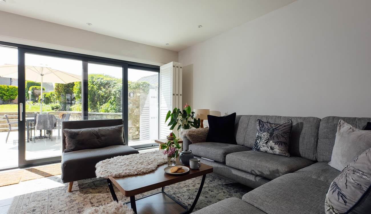 Sunshine streams into the tasteful sitting-room. 