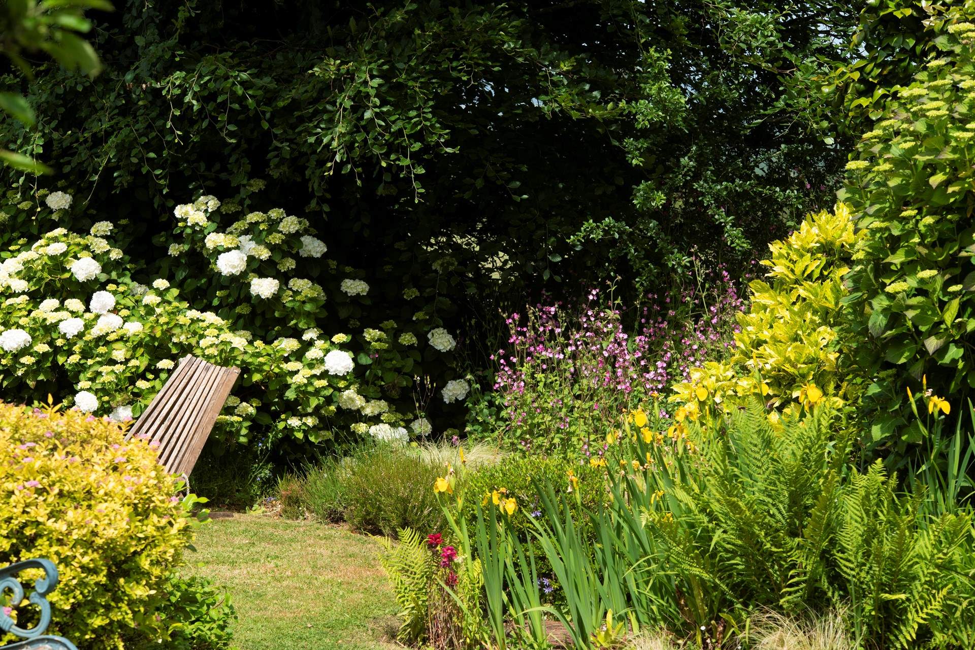 Well stocked borders create an enchanting space.
