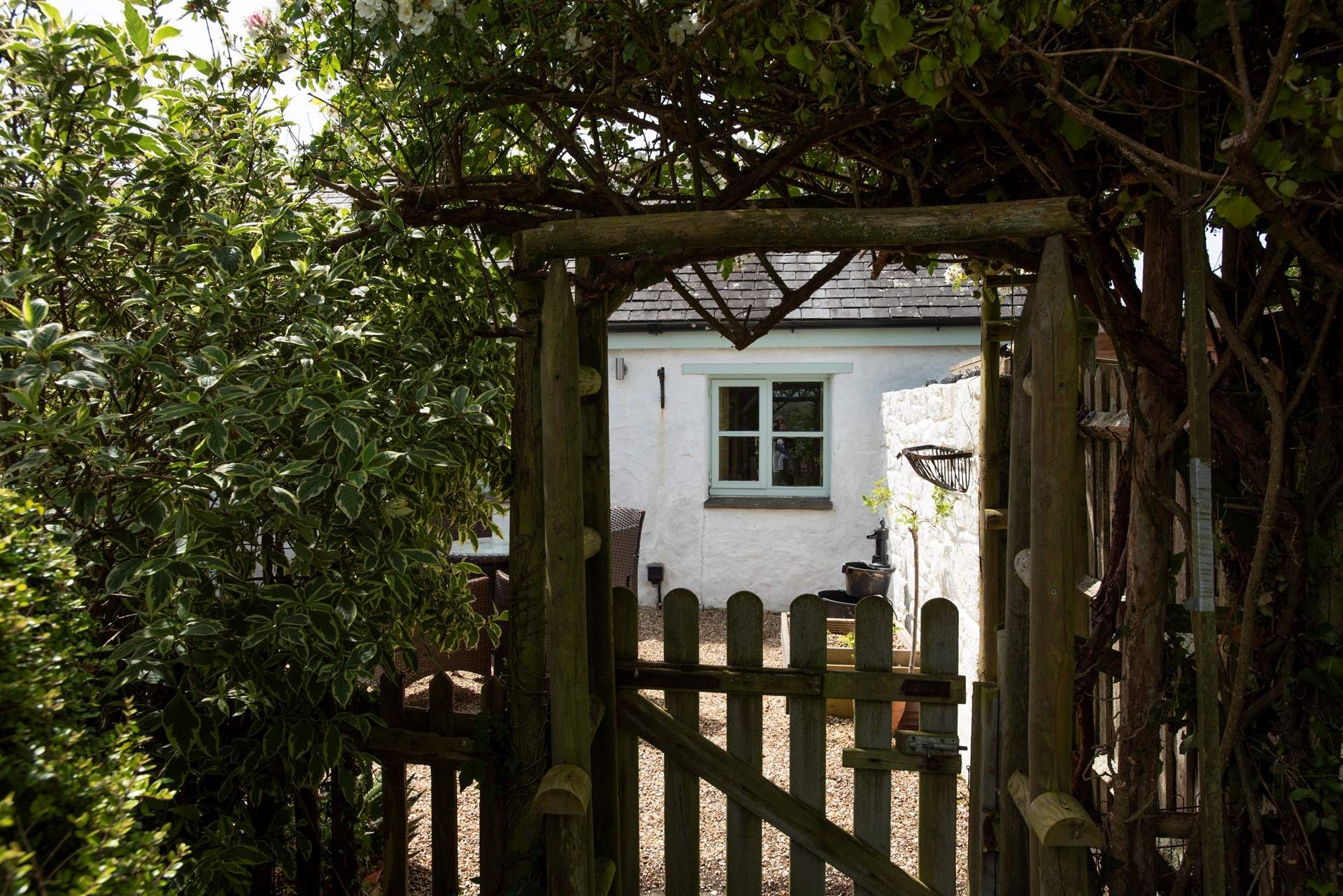 A glimpse through the garden gate reveals a picture perfect retreat.
