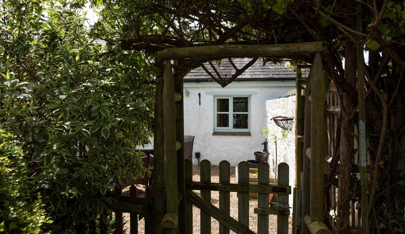 A glimpse through the garden gate reveals a picture perfect retreat.