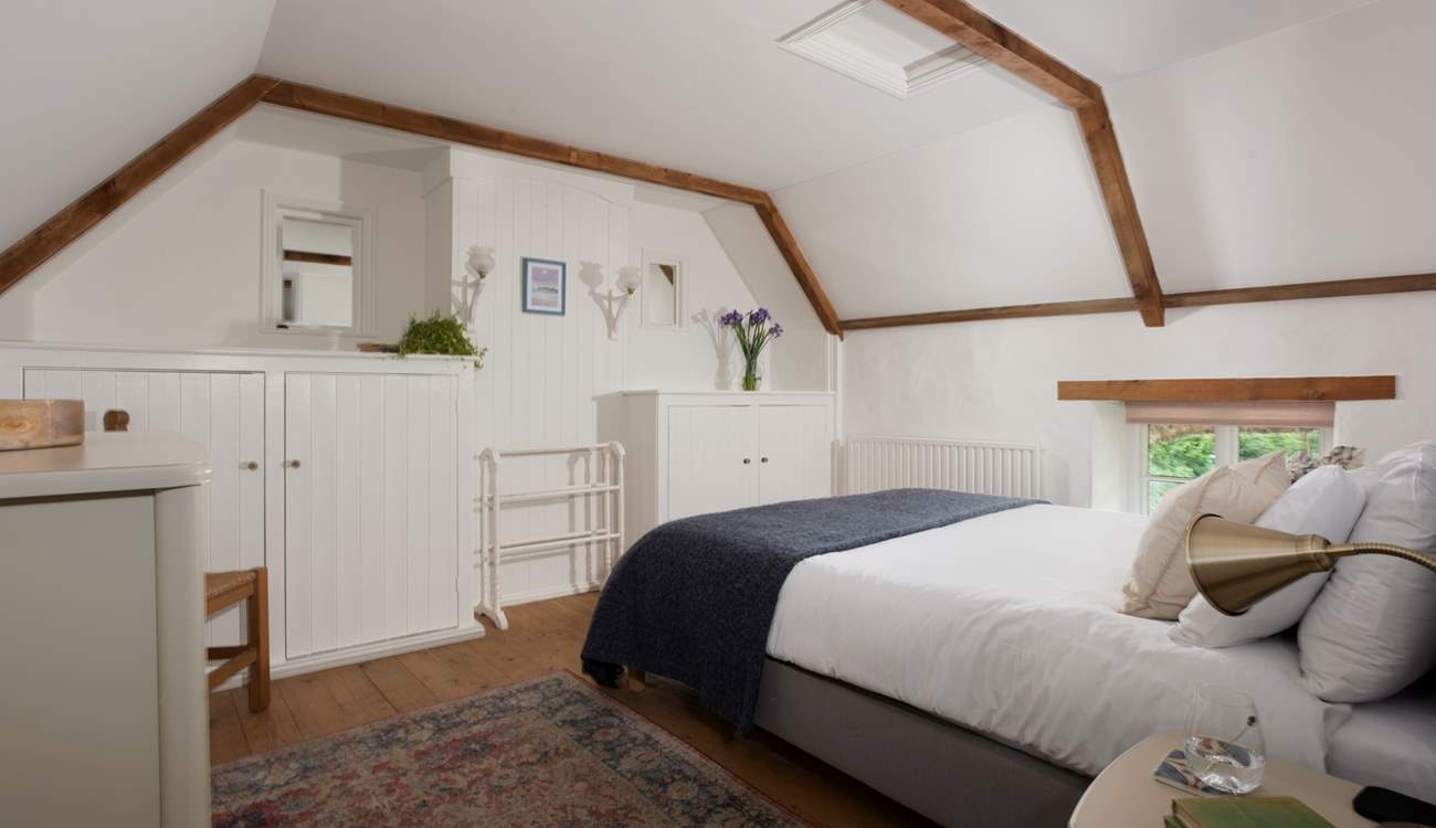 Bedroom 1 has a restful king-size bed and characterful wooden floors.