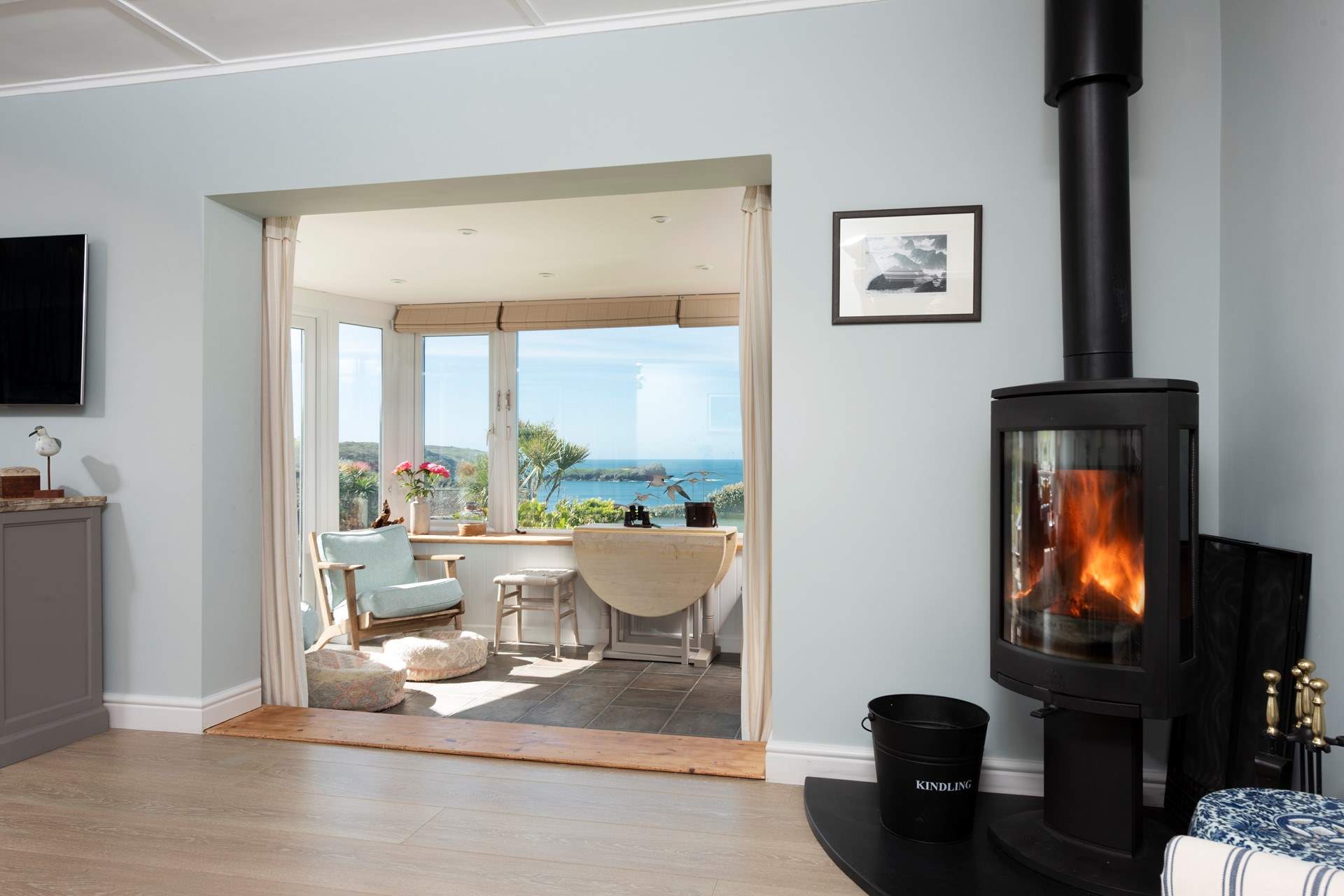 The sitting-room has  a wood-burner and opens up into the sun-room. 