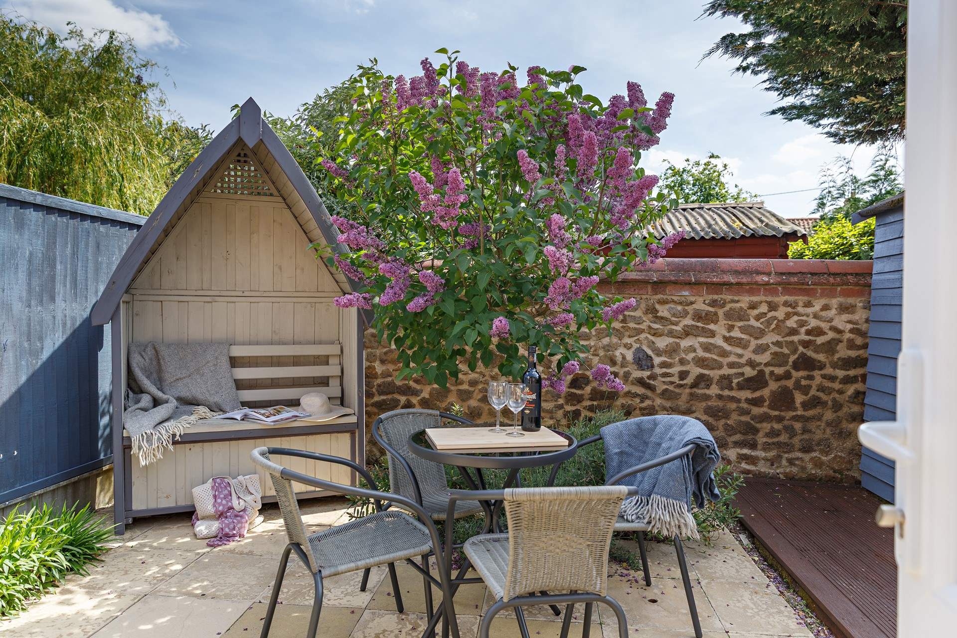 The rear patio is a charming, sheltered spot. 