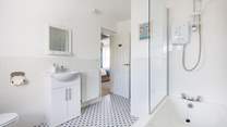 This light and bright bathroom has a bath with shower over.
