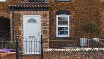 Bee's Cottage sits in a row of similar pretty cottages. 