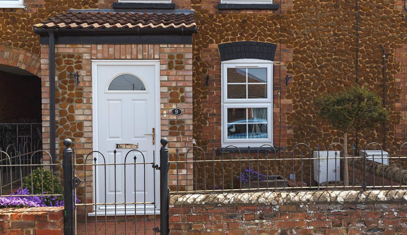 Bee's Cottage sits in a row of similar pretty cottages. 