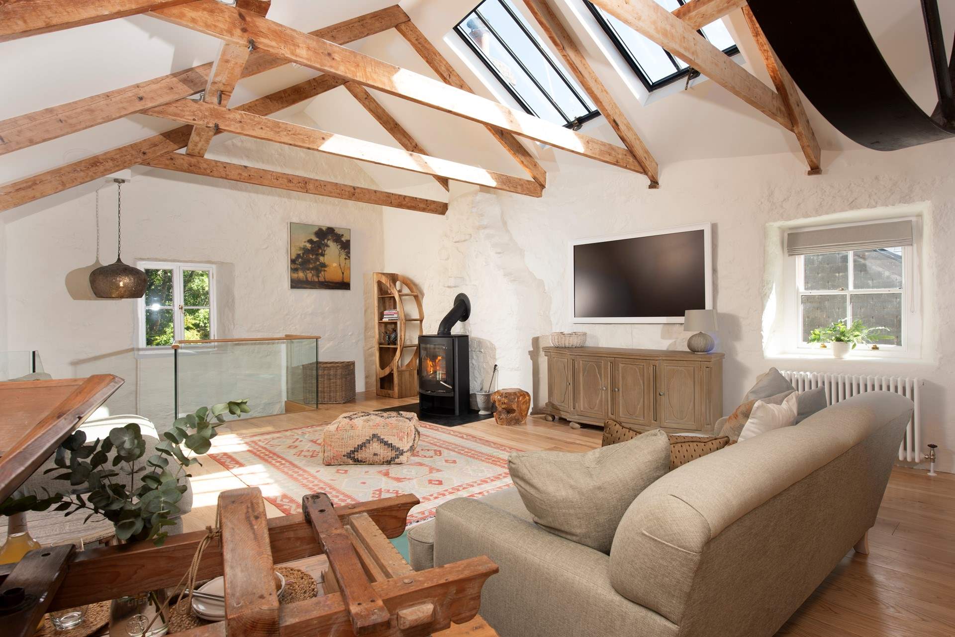 The sitting-room is upstairs above the kitchen with garden views and a cosy wood-burner.