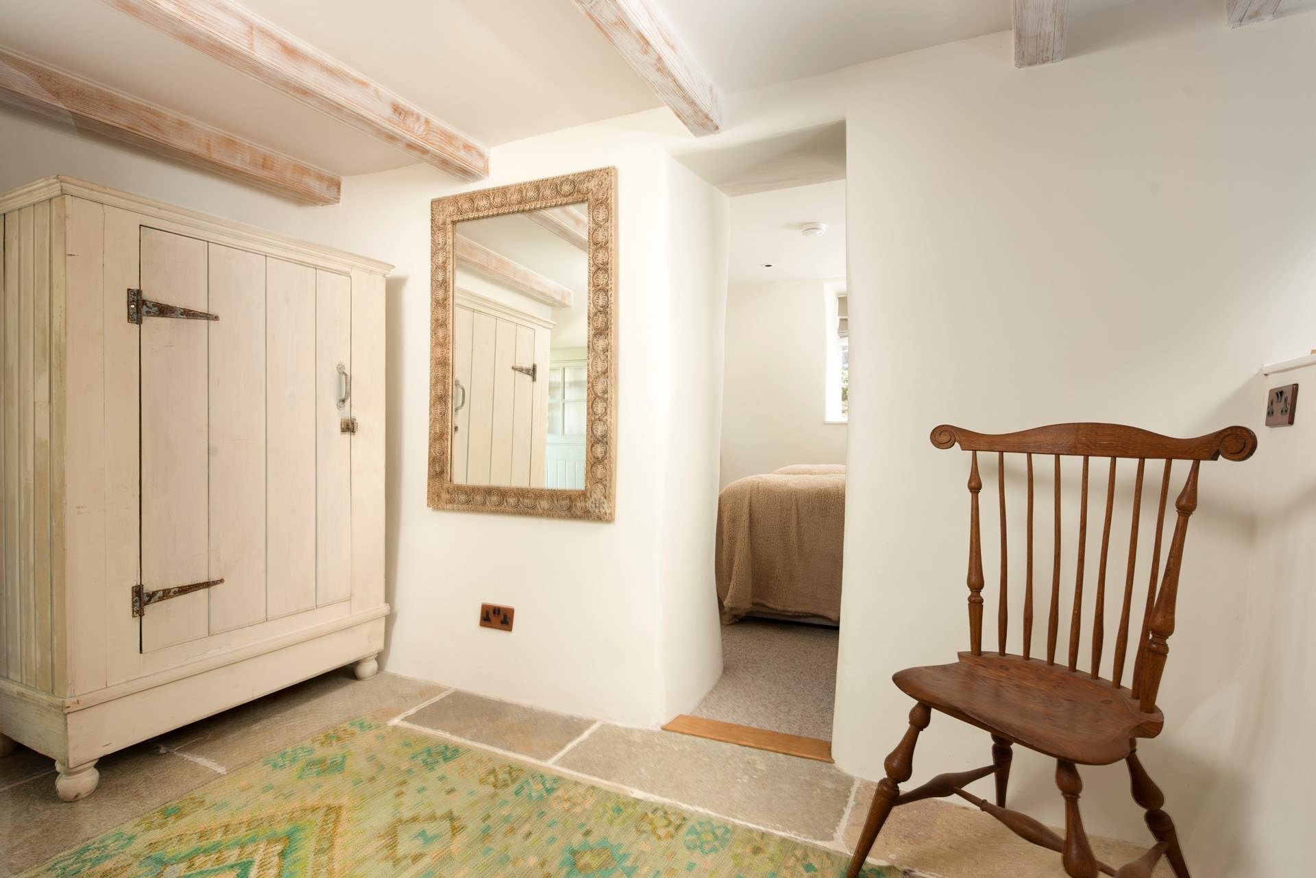 The dressing-room leading through to the bedroom, with its cute and narrow entrance.