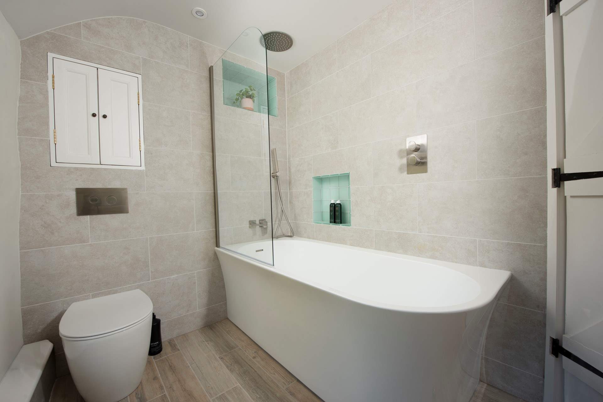 With both a bath and overhead power shower.