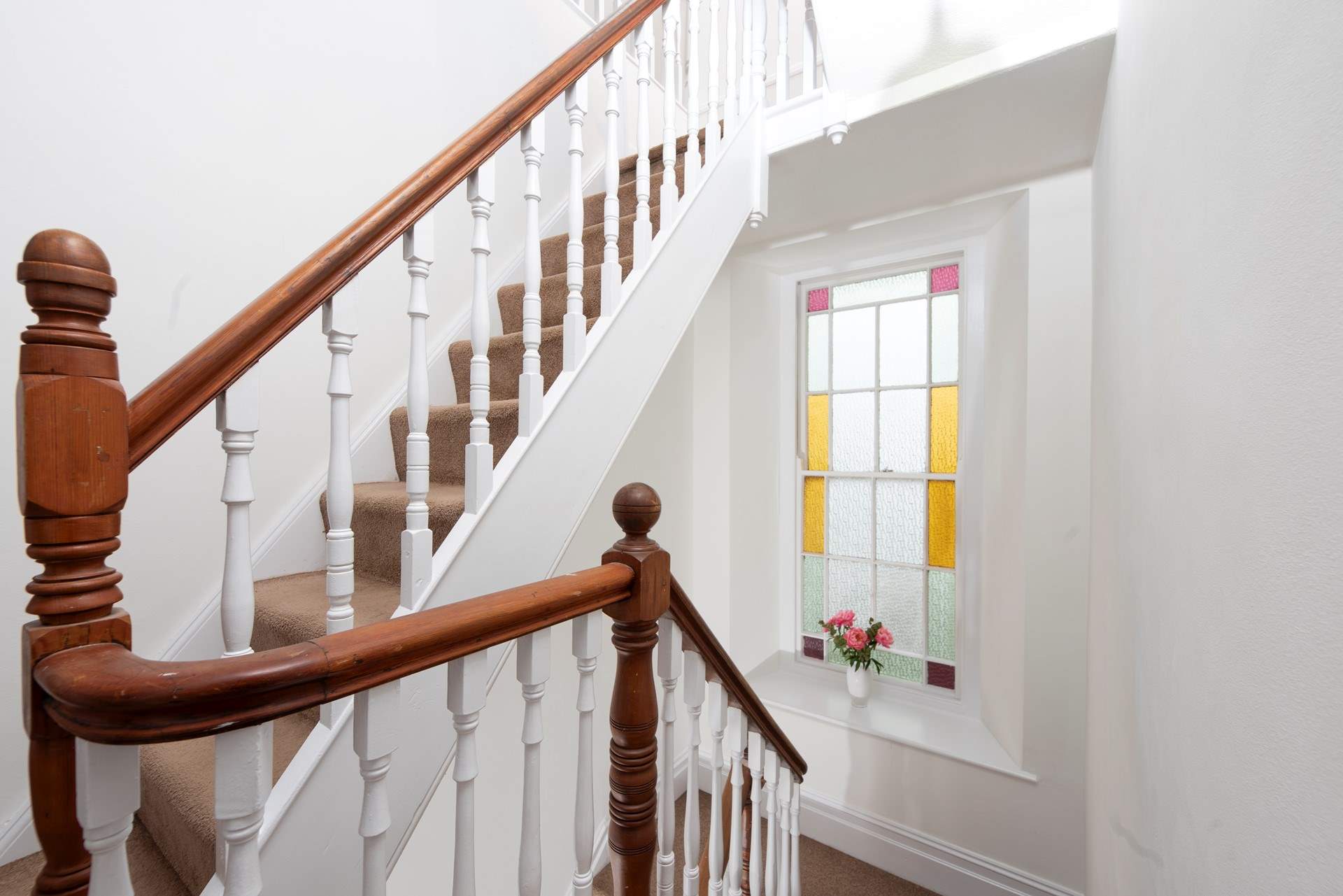 Character shines through the original staircase and stained glass window.