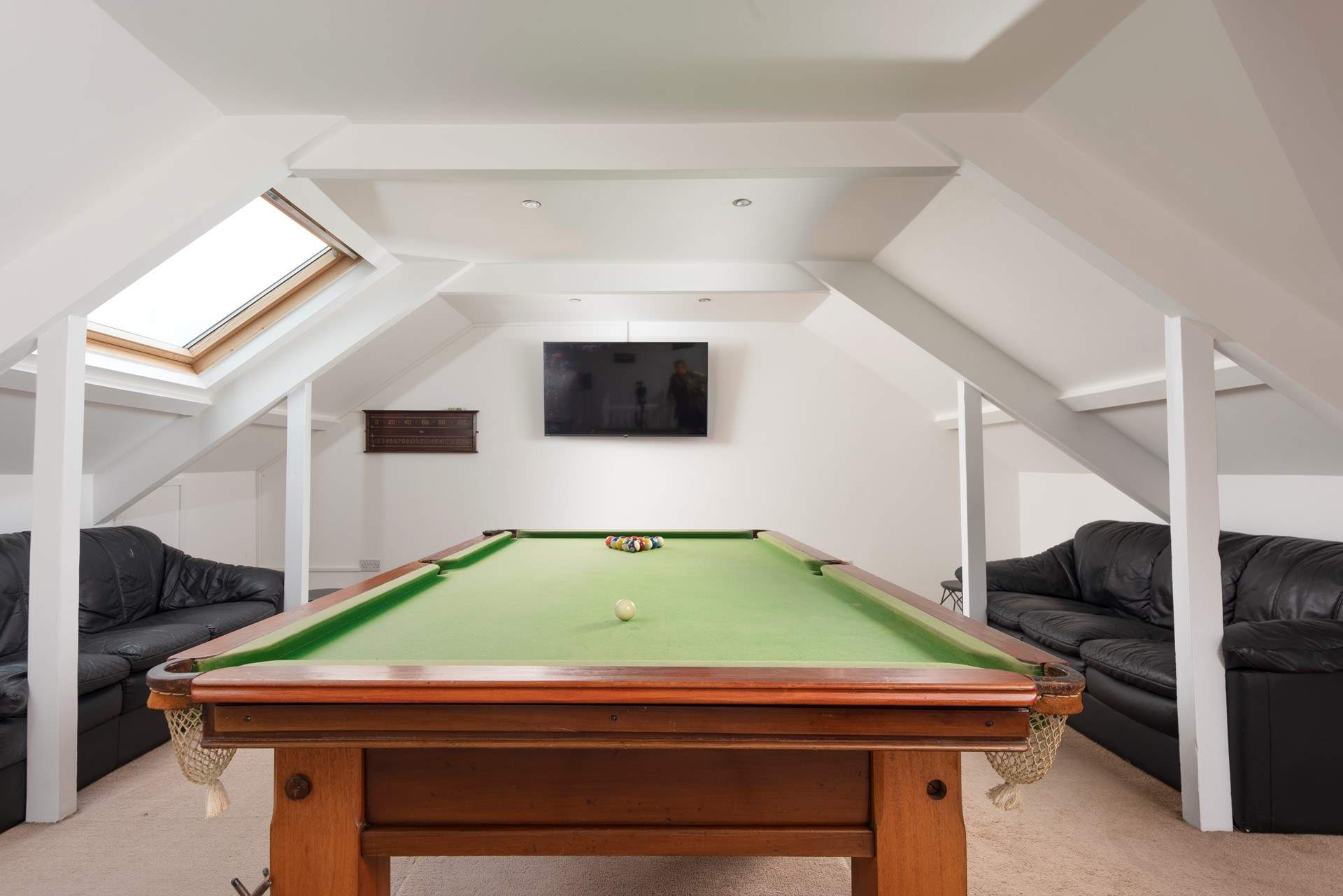 The games-room in the eaves of the house with a full size pool table and a Smart TV, perfect for a family night in! (Do mind your head).