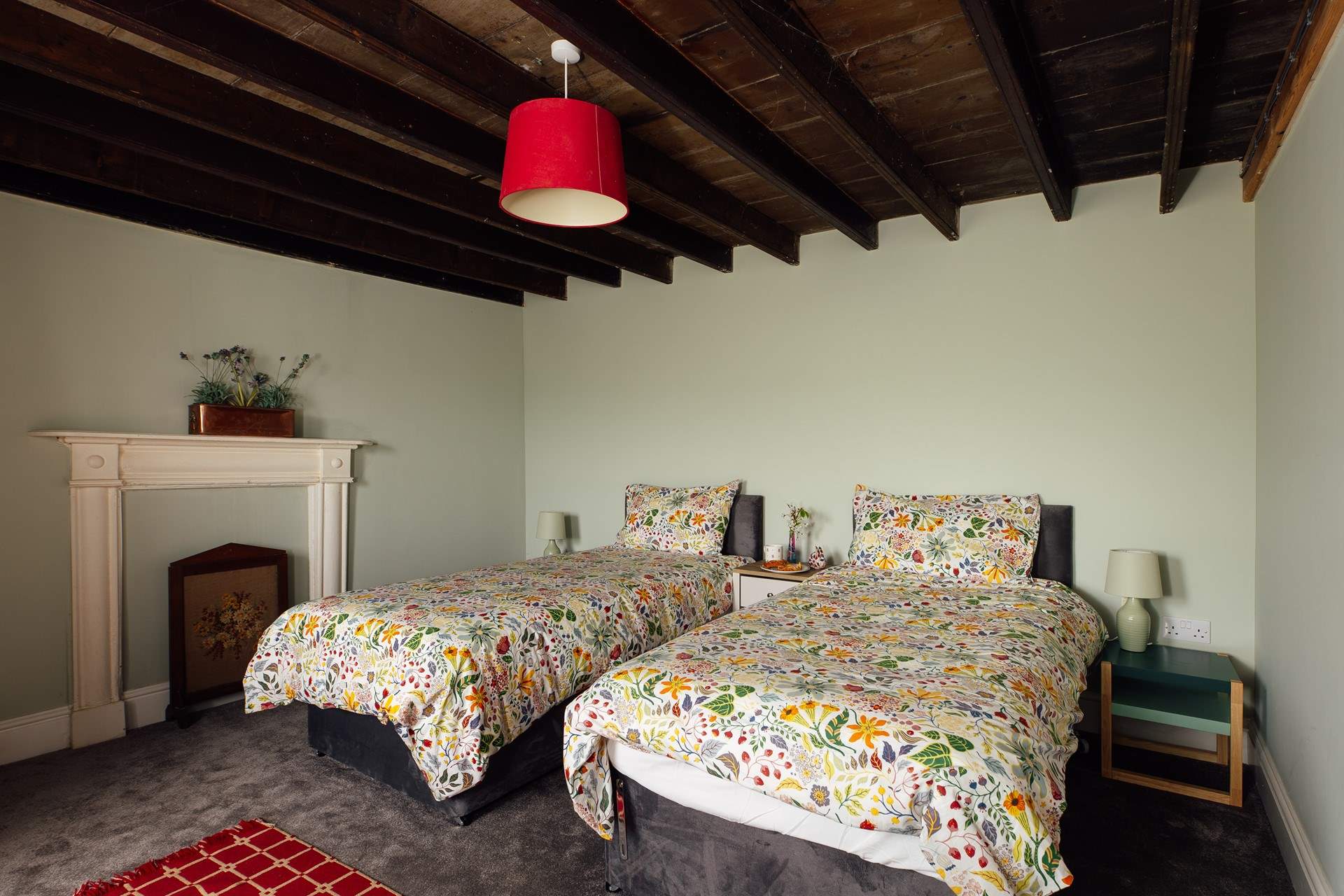 Sea facing twin room on the ground floor with exposed beams and traditional decorative fireplace. 