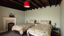 Sea facing twin room on the ground floor with exposed beams and traditional decorative fireplace. 